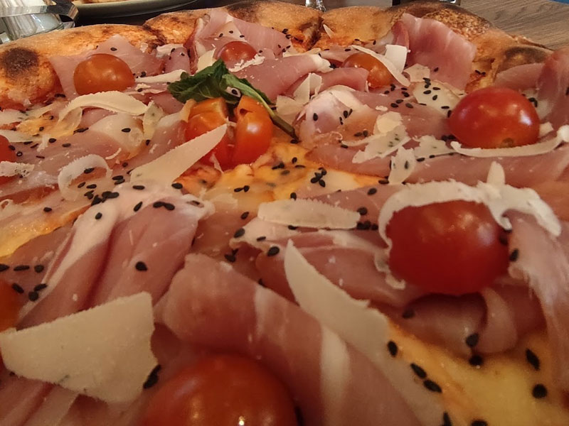 Pizza with arugula and prosciutto delivery