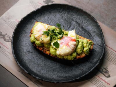 Poached eggs with guacamole on sourdough bread Balkan Distrikt delivery