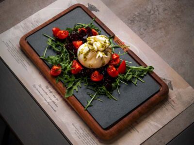 Homemade burrata gramina on arugula and cherry tomato Balkan Distrikt delivery