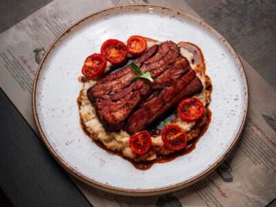 Veal ribs on celery puree with roasted cherry tomato Balkan Distrikt delivery
