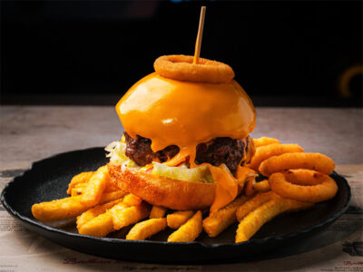 Angus premium burger on french fries and onion rings Balkan Distrikt delivery